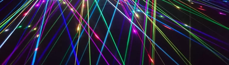 farbige Laserstrahlen vor dunklem Hintergrund