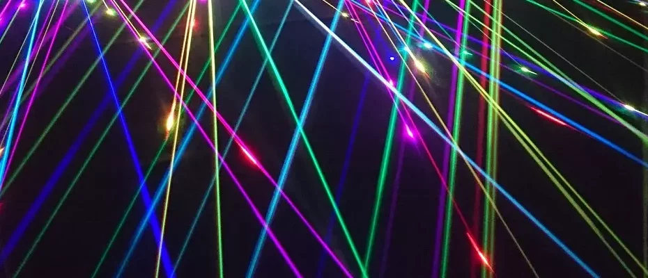 farbige Laserstrahlen vor dunklem Hintergrund