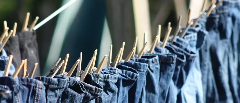 Jeans mit Wäscheklammern an einer Leine befestigt