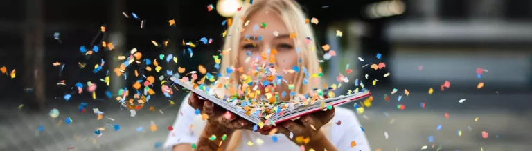 Frau mit aufgeschlagenem Buch und Konfetti